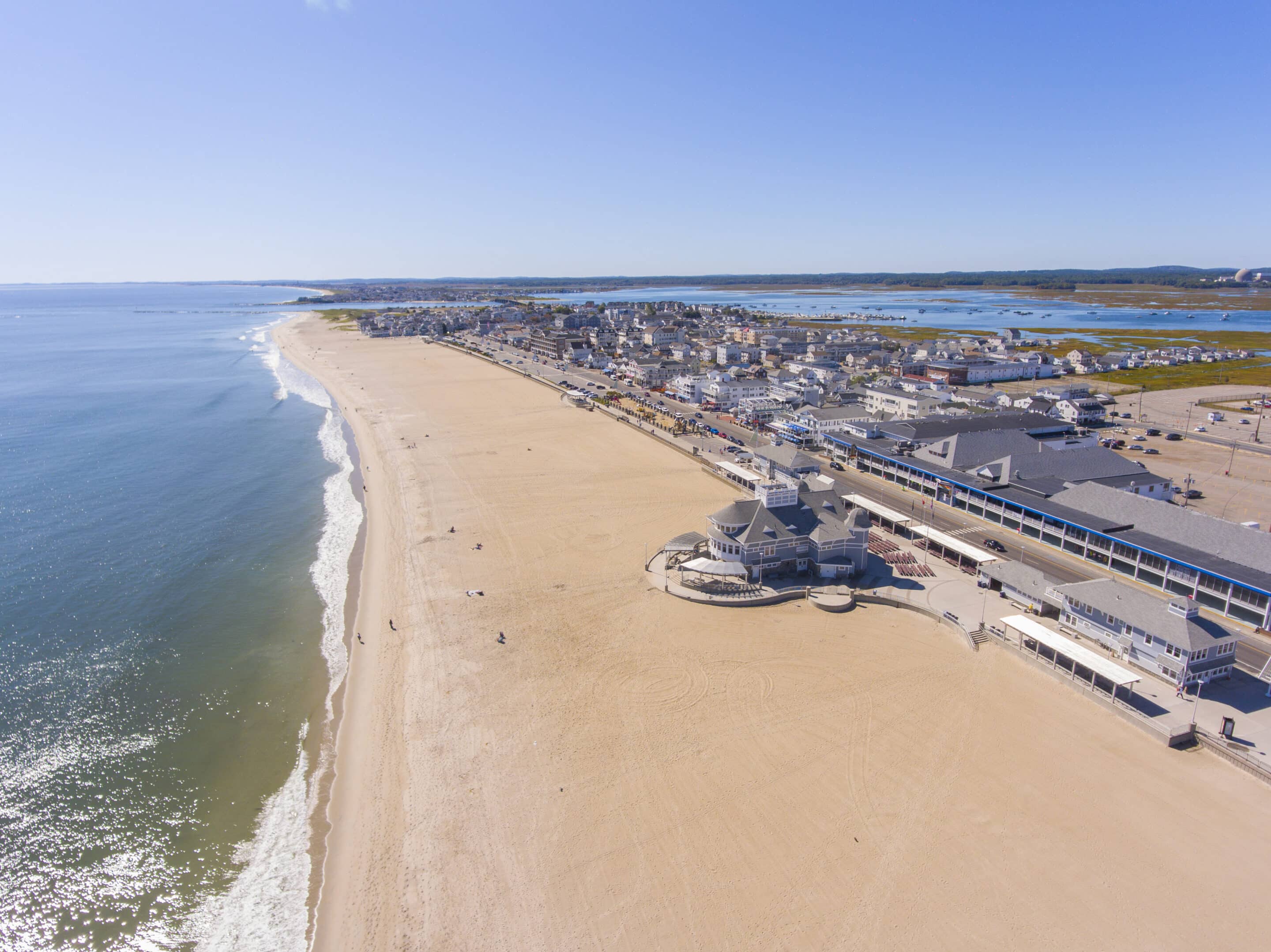 Aerial view of Hampton Beach with historic buildings on Ocean Boulevard, beachfront, and distant mountains at the NH-MA border. A prime example of an area that would greatly benefit from New Hampshire Flood Insurance.