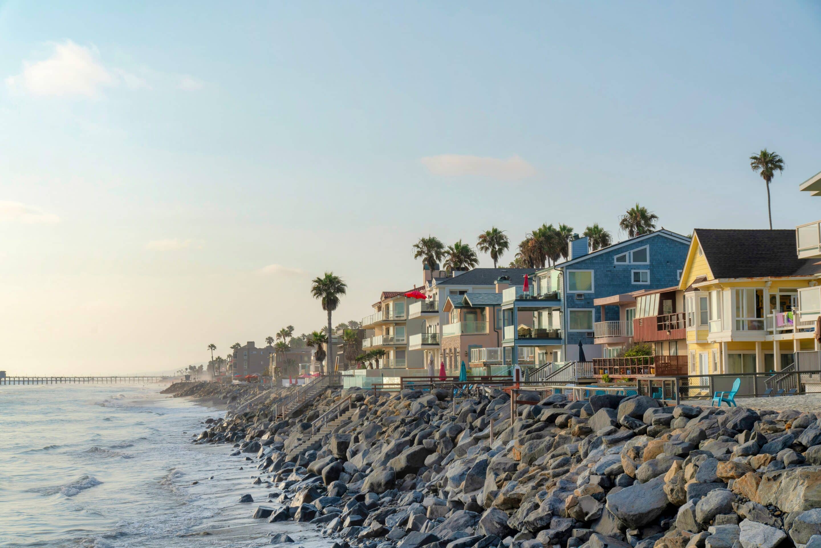 Colorful coastal homes along a beach, emphasizing the flood insurance cost for such areas.