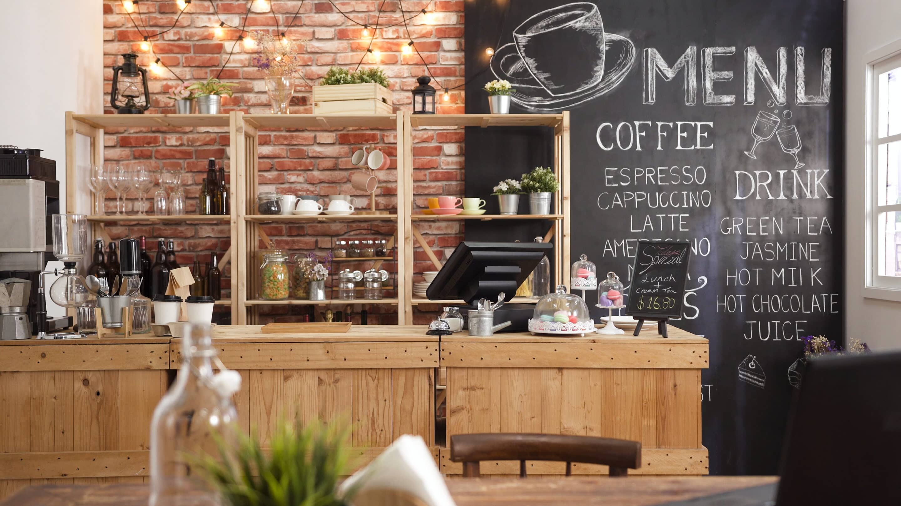 A cozy café interior with a rustic wooden counter, chalkboard menu, and warm lighting, emphasizing the importance of business insurance for small enterprises.
