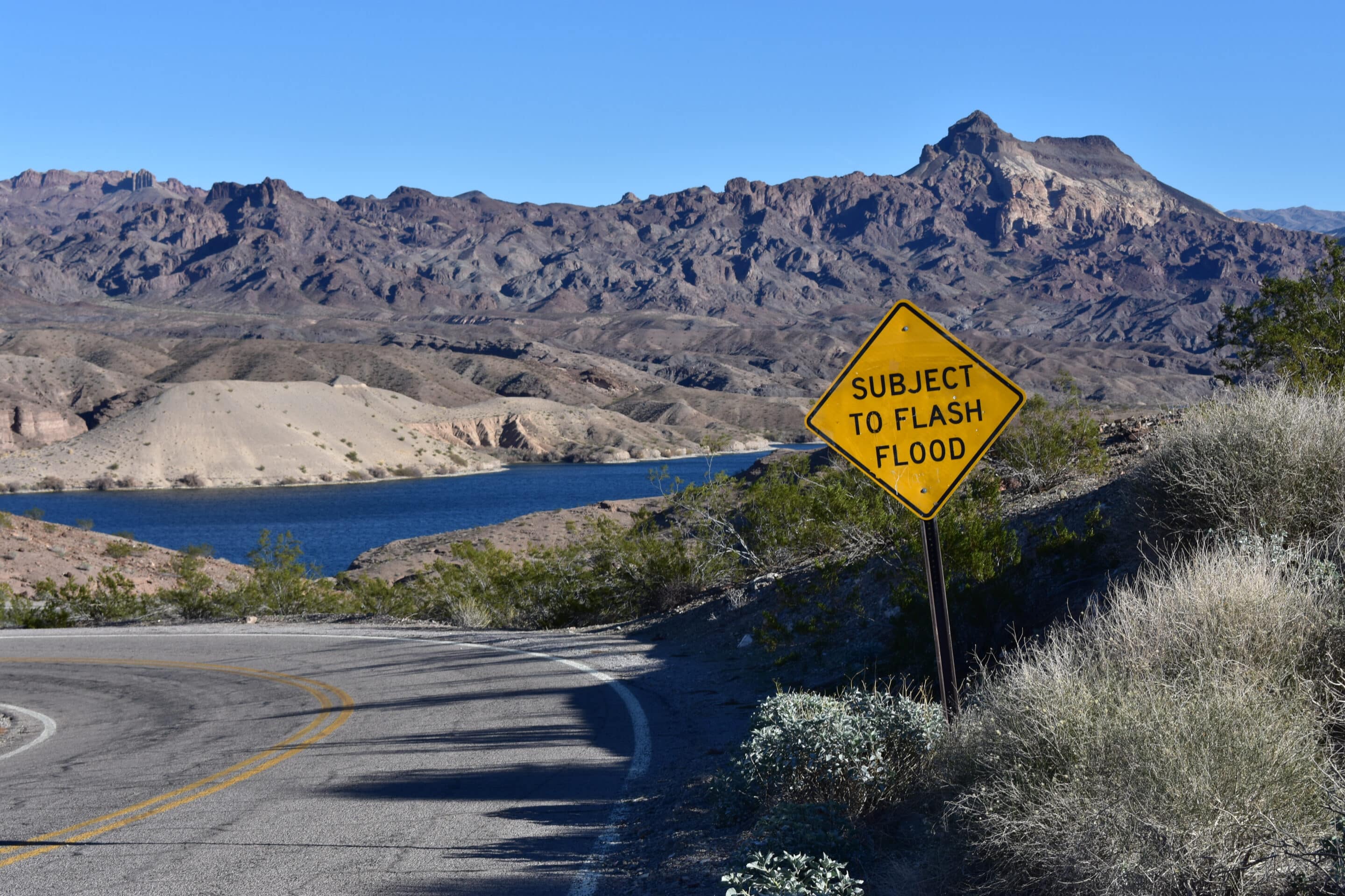 Road sign warning of flash floods in a dry Colorado canyon area.