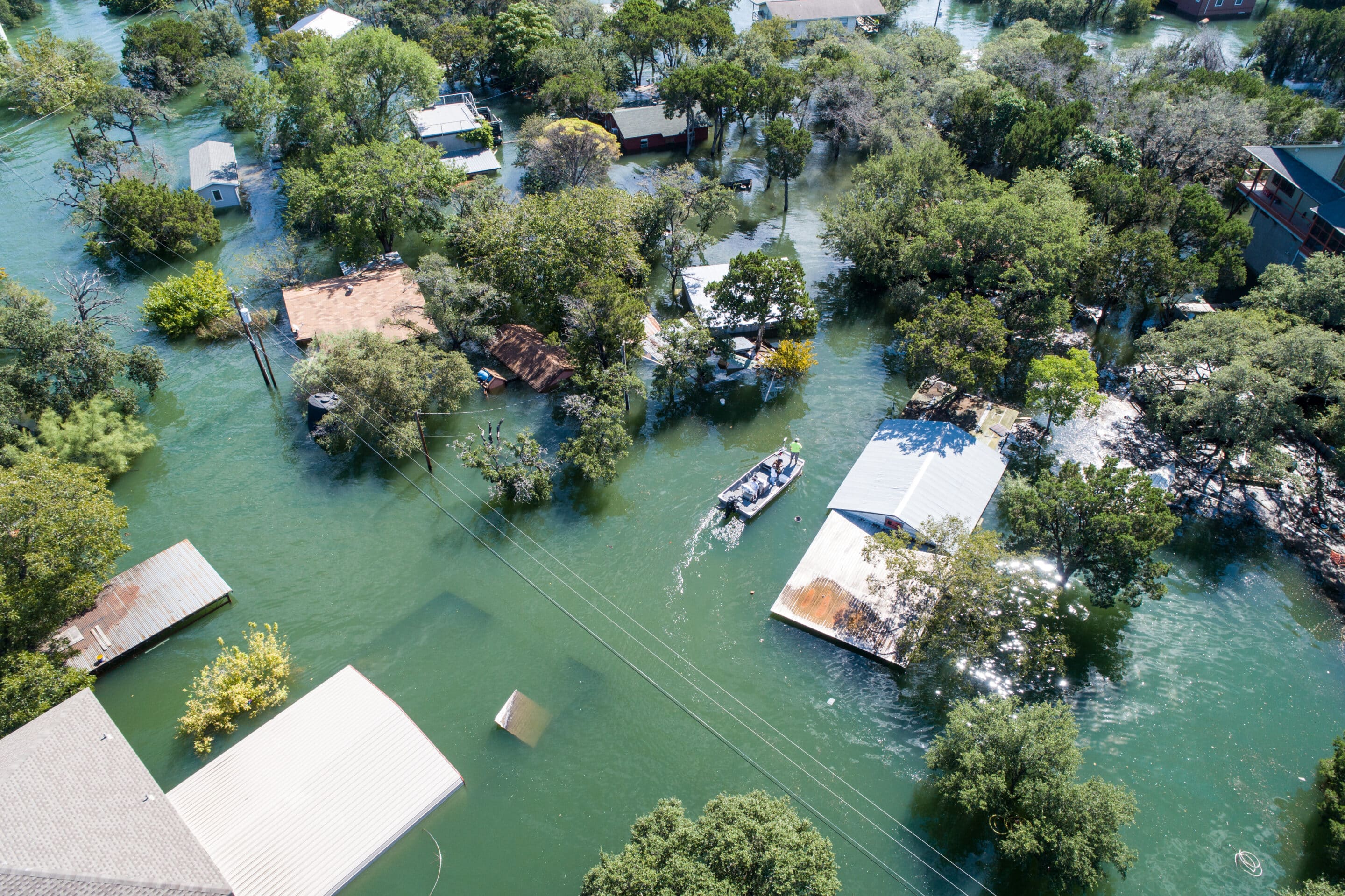 Flooded homes and trees submerged in water during a natural disaster in Colorado.