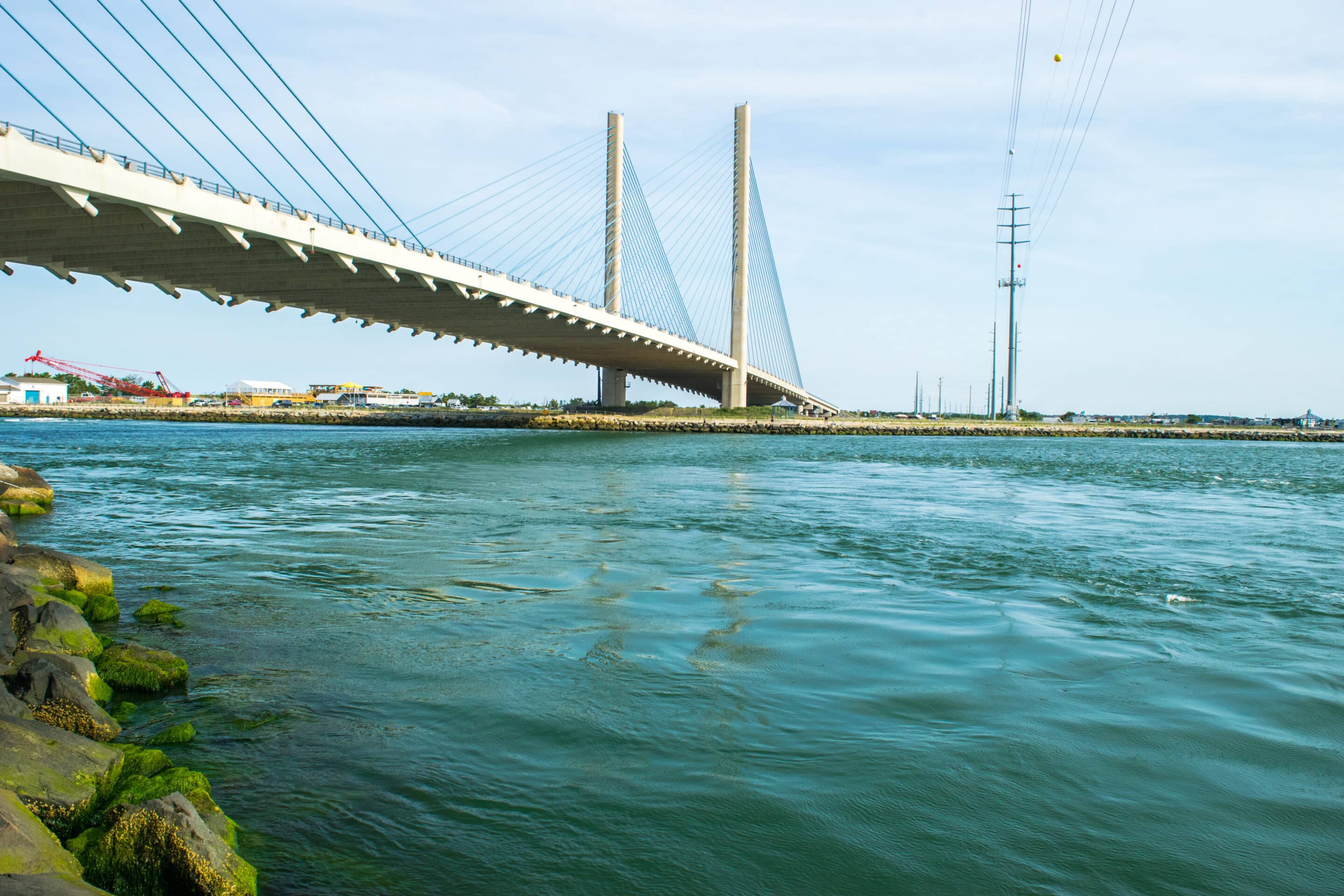 Cable-stayed Indian River Inlet Bridge over calm water with visible construction area.