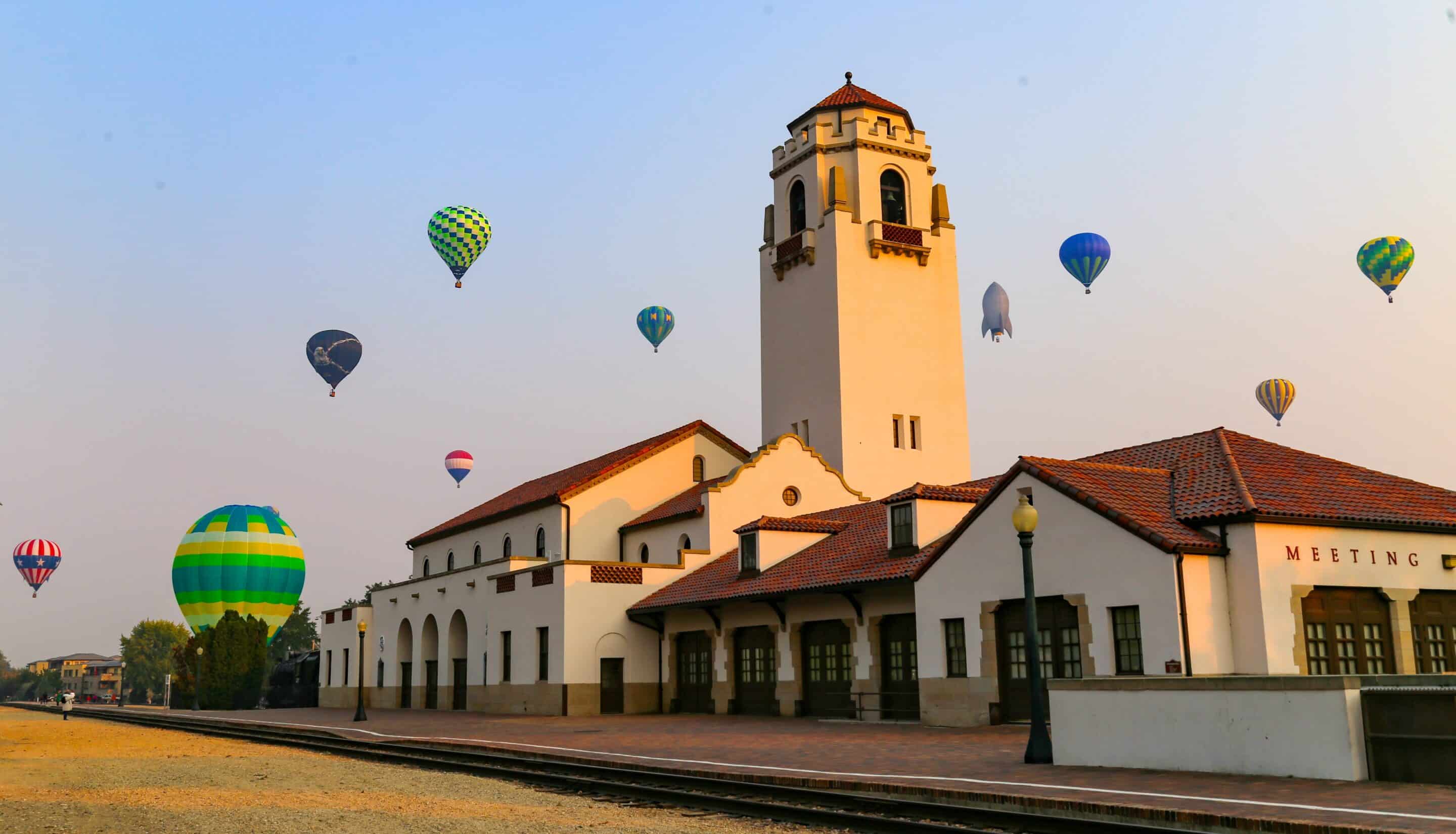 Boise Depot with hot air balloons floating in the sky on a clear morning.