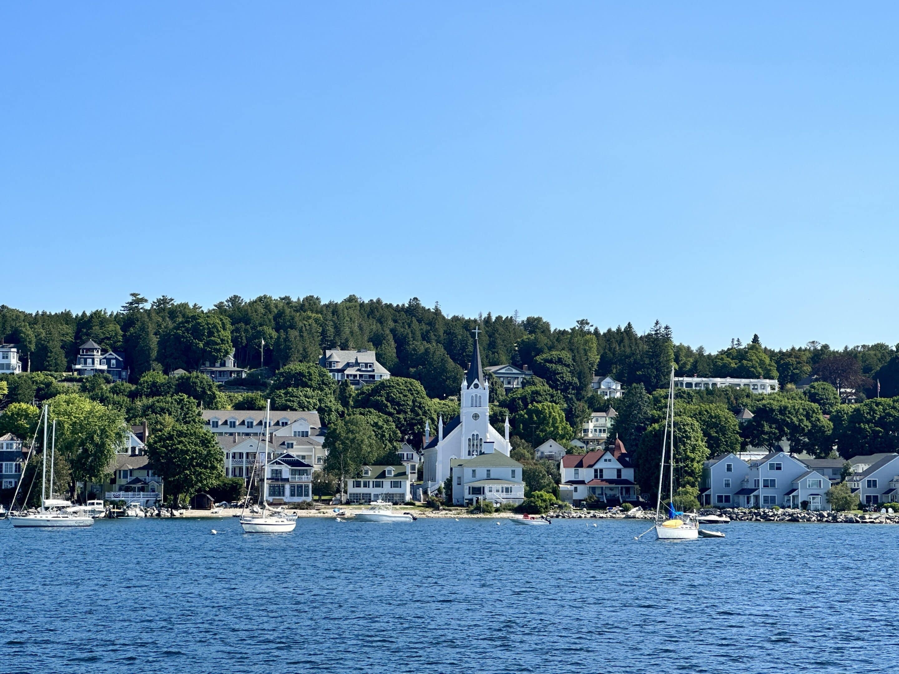 Mackinac Island waterfront with historic church and homes overlooking Lake Huron.