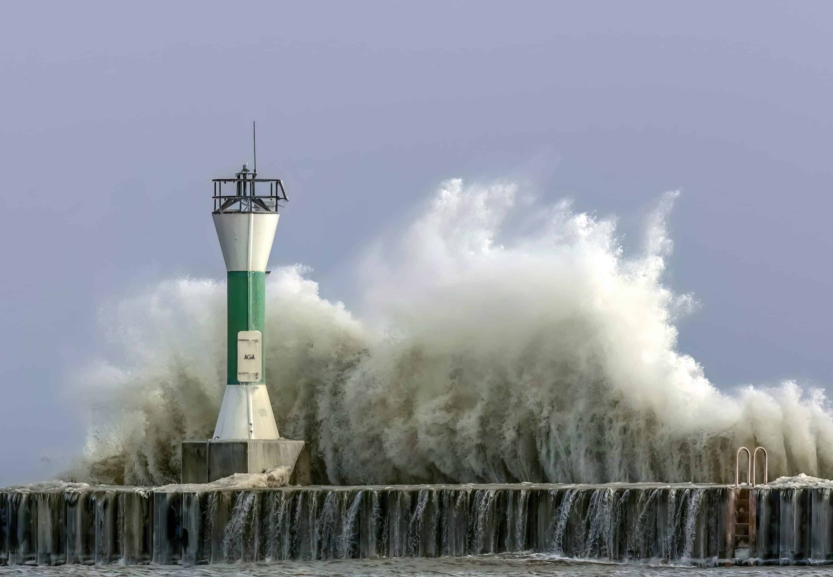Powerful wave crashes against a breakwater tower on Lake Michigan in Wisconsin.