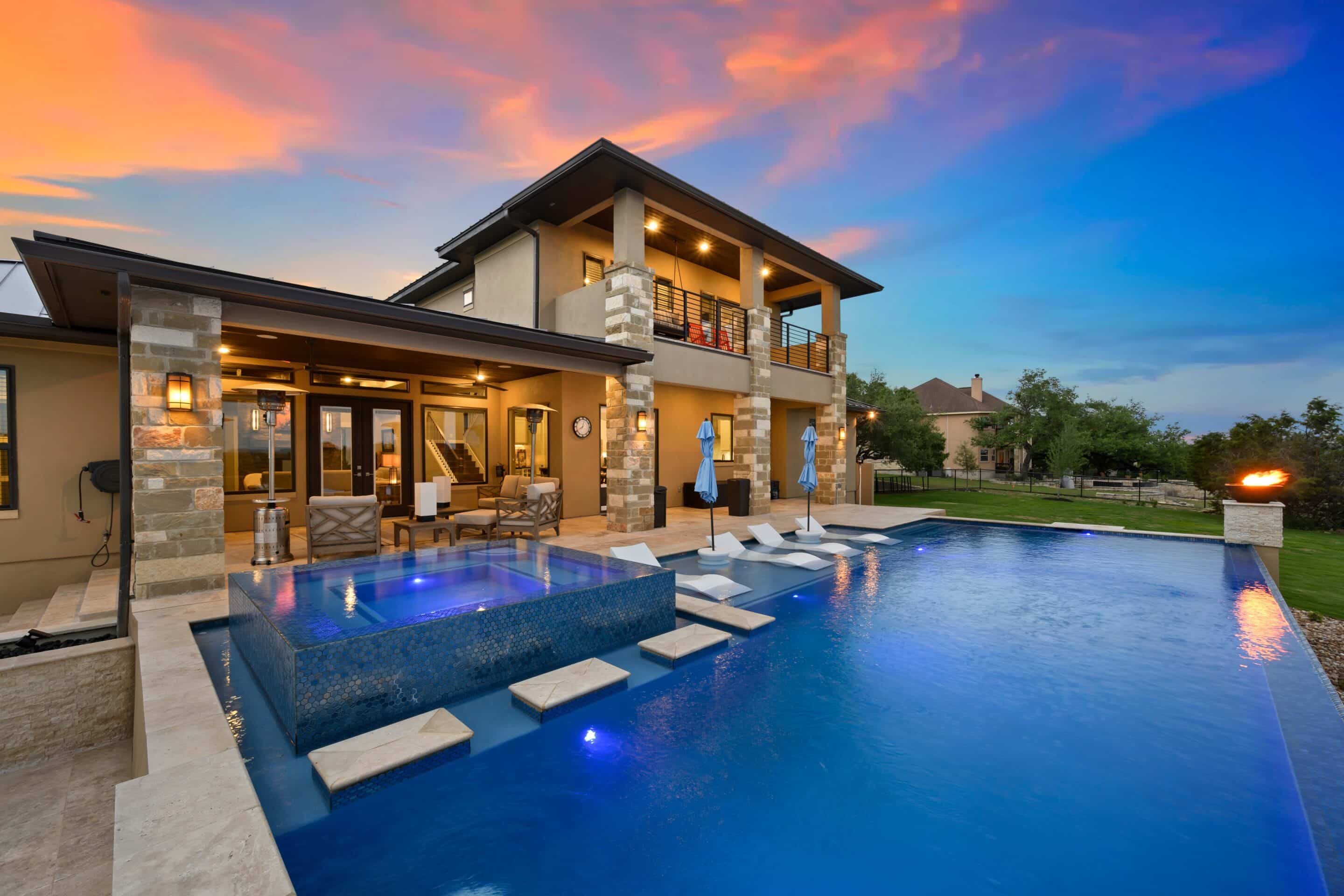 Modern luxury home with infinity pool at dusk — high value home insurance coverage