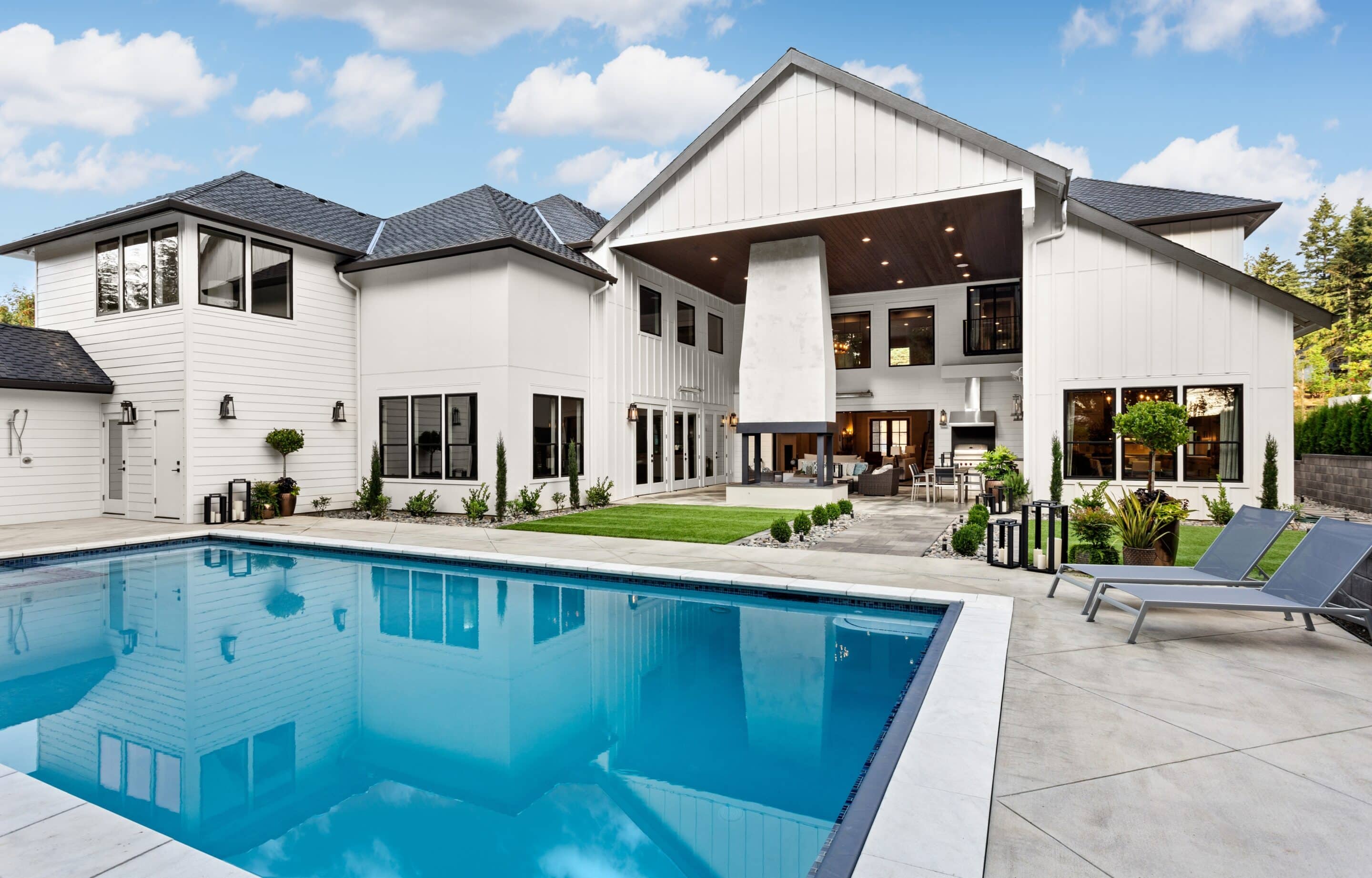 Large white modern farmhouse with pool representing cost to insure a million dollar home.
