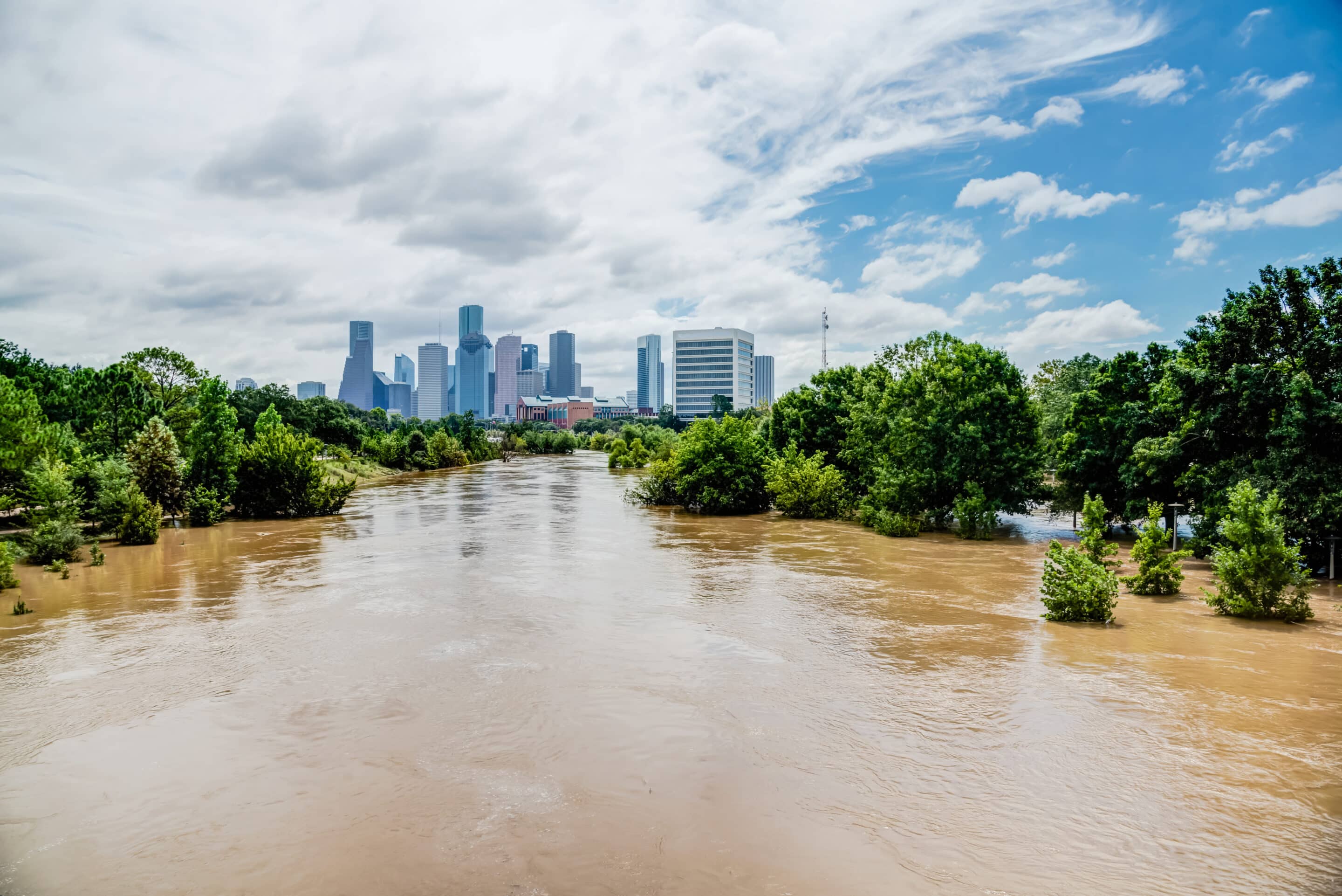 Urban Flooding and Insurance Trends 2025 Flooded river with city skyline in the background illustrating flood insurance needs in 2025