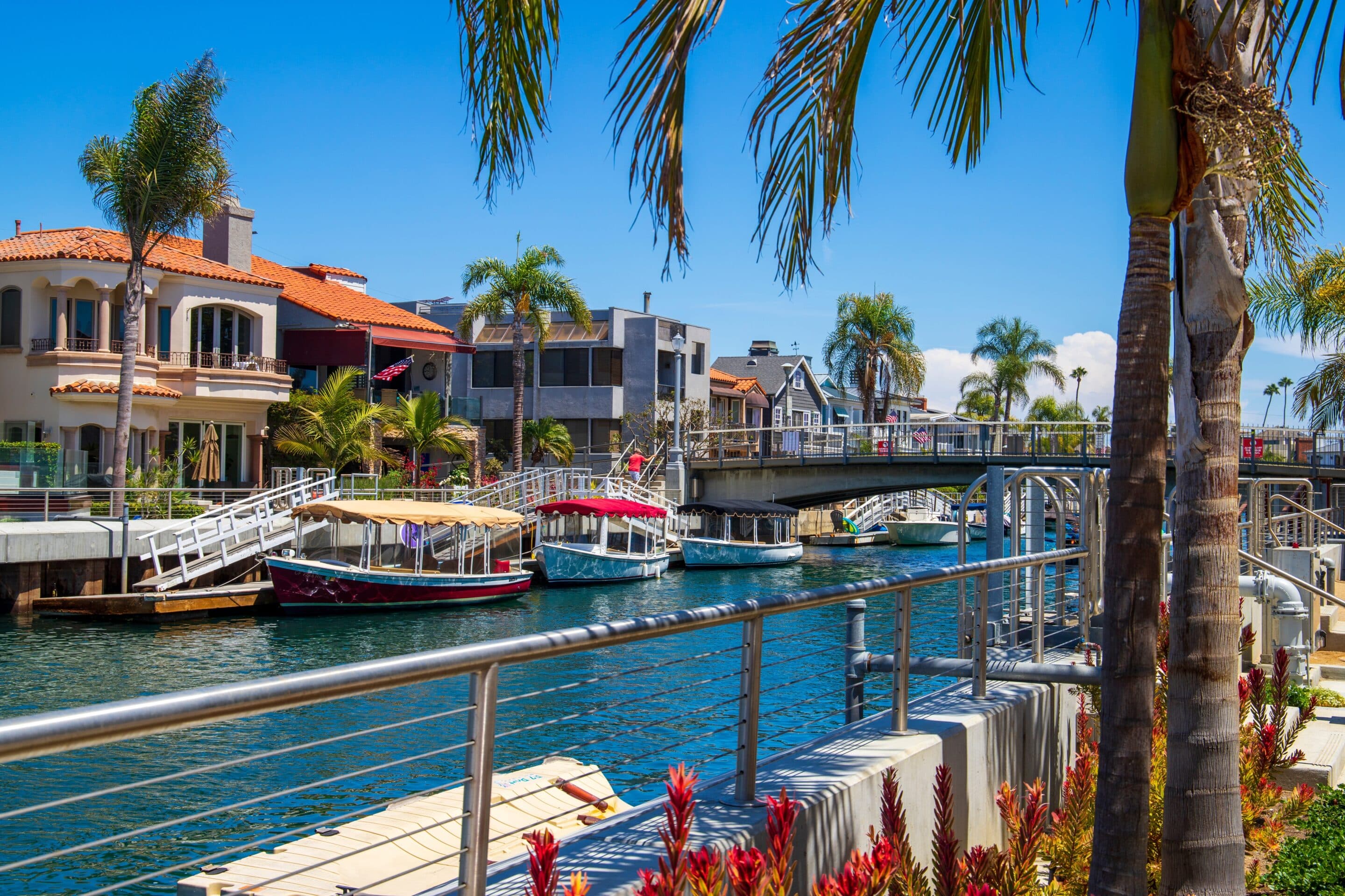 Flood Insurance 2025 for Waterfront Homes Waterfront homes and docked boats in a sunny canal neighborhood representing 2025 flood insurance coverage needs